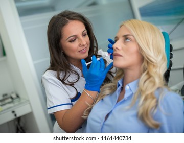 Cosmetologist Making Botox Injection In Female Lips