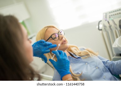 Cosmetologist Making Botox Injection In Female Lips