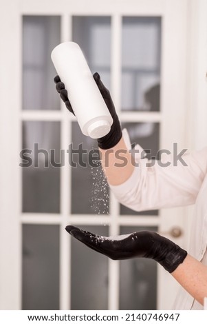 The cosmetologist pours out a special white talc on her hands