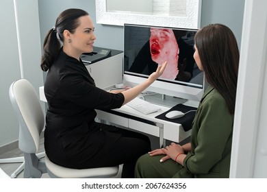 Cosmetologist showing female patient results of 3d picture of her face. Preperation for cosmetology procedure