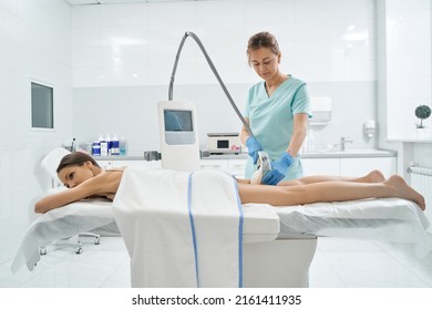 Cosmetologist using radio wave lifting on patient with vela shape
