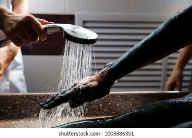 Cosmetologist Washing Off Clay Body Mask On Female Patient. Woman Getting Spa Treatment In Salon.Mud Therapy, Hydrotherapy. Close Up Of Hands