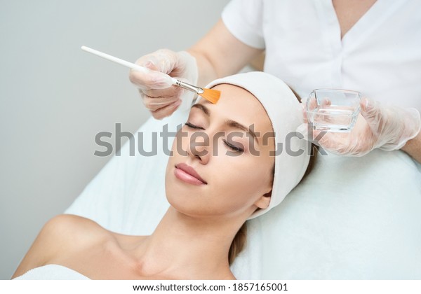 Cosmetology beauty procedure. Young woman skin\
care. Beautiful female person. Rejuvenation treatment. Facial\
chemical peel therapy. Clinical healthcare. Doctor hand.\
Dermatology\
cleanser.