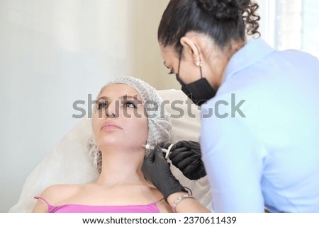 cosmetology clinic, where skilled aesthetician is seen injecting filler into jowls. procedure, focusing on reducing masseter lines and enhancing face shape