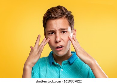 Cosmetology, Dermatology and acne. A Caucasian teenager in a blue t-shirt is upset about the appearance of acne. Yellow background. Copy space - Shutterstock ID 1619809822
