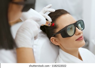 Cosmetology. Woman At Hair Growth Laser Stimulation Treatment