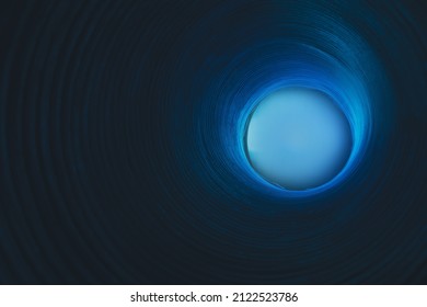 Cosmic abstract background. Blur glow. Galaxy portal. Defocused neon blue color light sphere on ribbed circles texture dark black copy space.