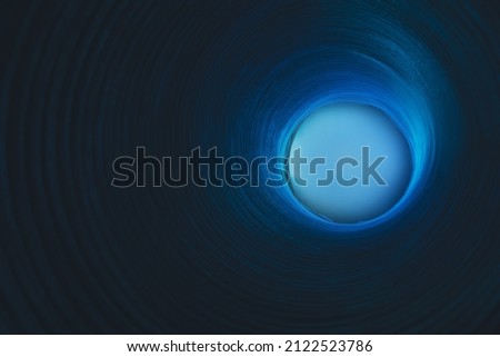 Cosmic abstract background. Blur glow. Galaxy portal. Defocused neon blue color light sphere on ribbed circles texture dark black copy space.