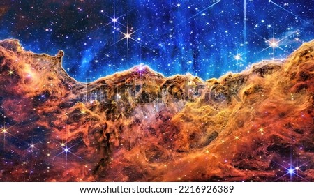 Cosmic Cliffs in the Carina Nebula. Seen by telescope in visible light, capturing the multi-coloured glow of gas clouds in deep space. Elements of this image are furnished by NASA