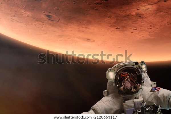 Cosmonaut in deep space with Mars\
planet background. Elements of this image furnished by NASA.\
