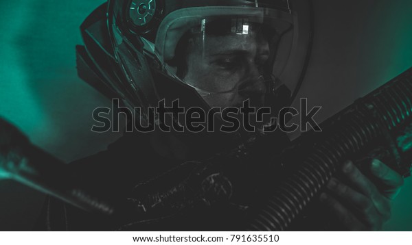 Cosmonaut,\
man of the future or space with futuristic helmet and fantasy\
lights, carries a laser weapon in his\
hands