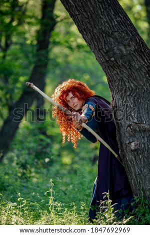 cosplay Brave red curly girl with a bow in the woods