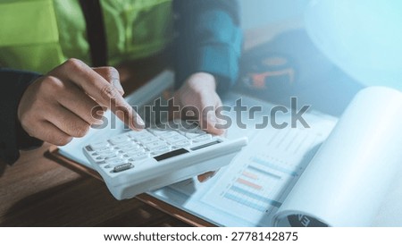 Cost estimation construction budget planning concept engineer hands using calculator analyzing financial report chart graph expense pricing audit working with hard hat tape measure on desk