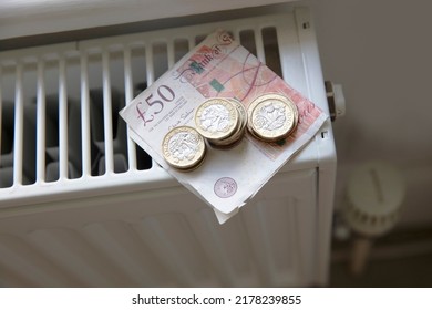 Cost of living crisis. Money on a home radiator heater. Rising cost of energy and bills - Shutterstock ID 2178239855