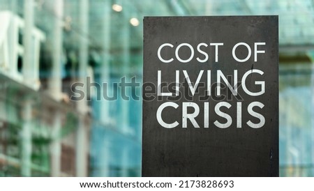 Cost of Living Crisis on sign in a downtown city setting	
