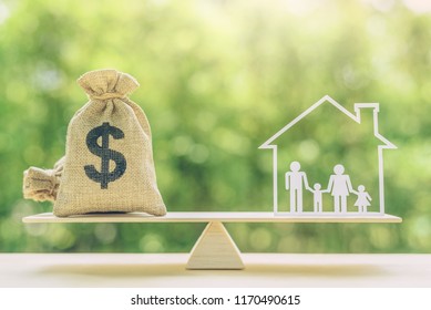 Cost Of Living, Home Loan, Family Finance And Child Trust Fund Concept : US Dollar Bags, Family Members Live Inside A House On Basic Balance Scale, Depicts The Expenditure A Family Should Prepare For