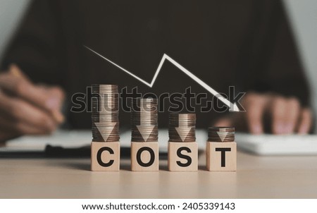 Cost reduction concept. Cost wording on decreasing coins stacking with the down arrow. Businessman working on company cost saving. Cost Management, Economy recession, low budget, Effective business,