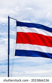 Costa Rican Flag Waving In A Strong Wind From Caldera Beach With The Sky In The Background.