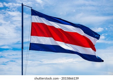 Costa Rican Flag Waving In A Strong Wind From Caldera Beach With The Sky In The Background.