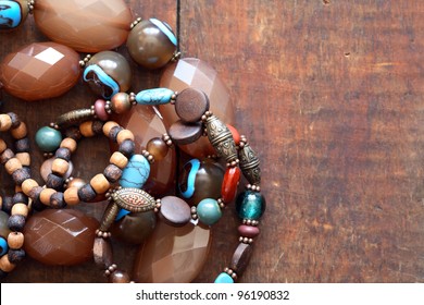 Costume Jewelry. Vintage female bracelets and necklace on wooden surface