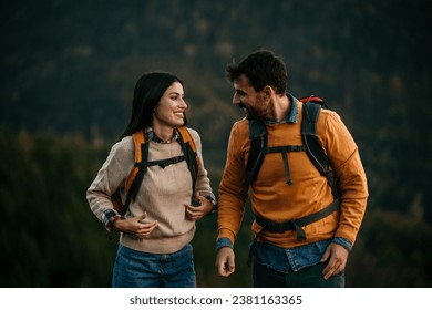 Cosy camping of a loving couple, gazing at the picturesque lake behind, as they prepare to leave, backpacks in hand - Powered by Shutterstock