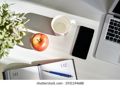 Cosy Home Office Desk With Laptop Computer And Phone. Still Life, No People.