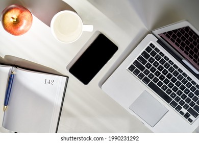 Cosy Home Office Desk With Laptop Computer And Phone. Still Life, No People.