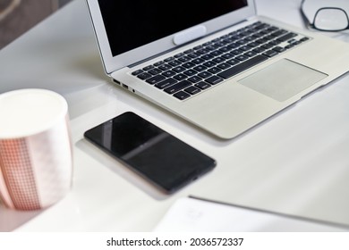 Cosy Home Office Desk With Laptop Computer And Phone. Still Life, No People.