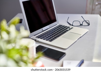 Cosy Home Office Desk With Laptop Computer And Phone. Still Life, No People.