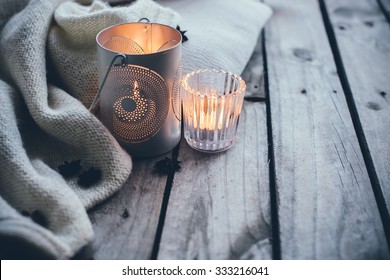 Cosy And Soft Winter Background, Knitted Sweater And Candles On An Old Vintage Wooden Board. Christmas Holidays At Home.