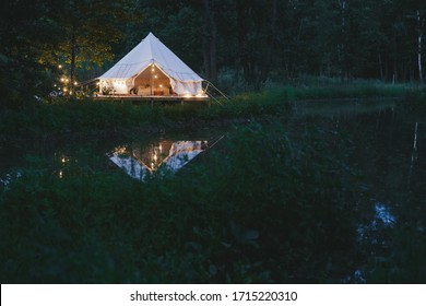 cosy trendy design and decorated bell tent in nature Glamping (glamorous camping) near river and forest 