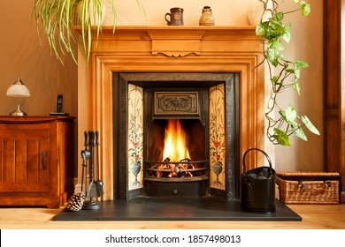 Cosy winter living room fireplace, with open fire with real flames burning coal, UK home interior