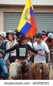 COTACACHI, ECUADOR - JUNE 25, 2016: Inti Raymi, The Quechua Solstice Celebration, With A History Of Violence In Cotacachi.  Men Stomp And Dance Under The Ecuadorian Flag.