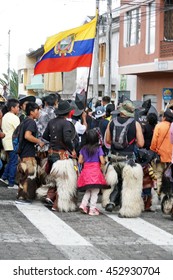 COTACACHI, ECUADOR - JUNE 25, 2016: Inti Raymi, The Quechua Solstice Celebration, With A History Of Violence In Cotacachi.  Men Stomp And Dance Under The Ecuadorian Flag.