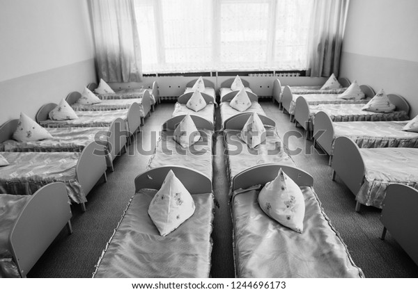 Cots in the\
kindergarten. Orphanage or boarding school. Beds in a boarding\
school or in an orphanage.