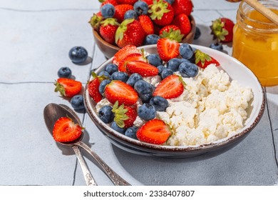 Cottage cheese with berries. Bowl of cottage cheese with strawberry, blueberry, high-protein summer healthy breakfast or lunch, copy space