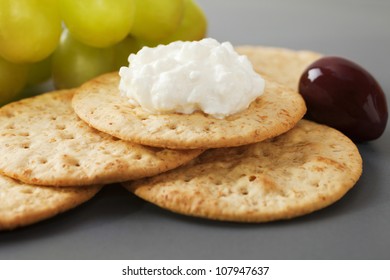 Cottage Cheese With Crackers, Grapes And Olives On A Dark Platter.