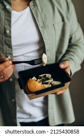 Cottage Cheese Dessert With Fruits In A Paper Bowl. A Man In Casual Clothes Holds A Portion Of Food From Delivery Or Food To Go.