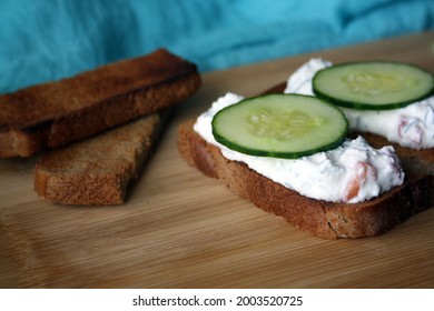 Cottage Cheese Dip With Cucumber Slices On Black Bread Toast. Breakfast. Space For Text.