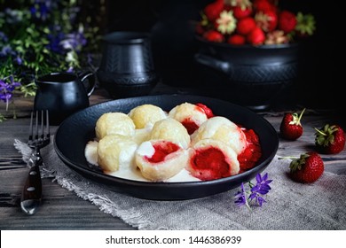 Cottage cheese dumplings with strawberries. Knedliki - czech cuisine. Fresh strawberry pot on dark background.