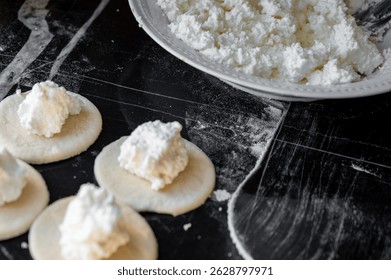 Relleno de queso cottage colocado en la envoltura de masa redonda, proceso de hacer dumplings