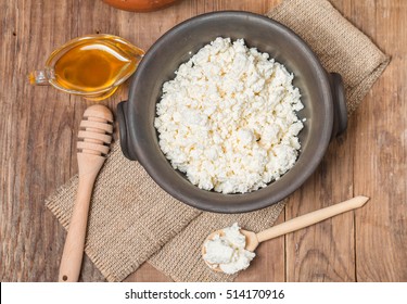 Cottage cheese with honey in a clay bowl on rustic background, top view - Powered by Shutterstock