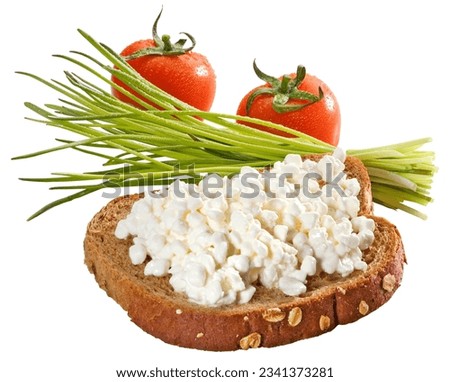Cottage cheese on a slice of whole grain bread with a small sheaf of chive and two small tomatoes in the background isolated on white + clipping path.