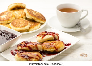 Cottage cheese pancakes with a cup of tea on the white wooden background. - Shutterstock ID 358634654