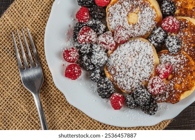 Cottage cheese pancakes with fresh raspberries, blackberries and powdered sugar - Powered by Shutterstock