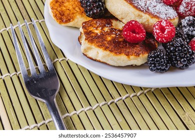 Cottage cheese pancakes with fresh raspberries, blackberries and powdered sugar - Powered by Shutterstock