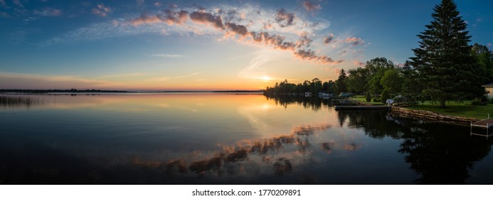 Cottage lake in Canada - Beautiful sunrise/sunset clouds reflecting in a lake at a cottage. Quiet, peaceful, serene. Gorgeous clouds in sky. Balsam Lake Kawartha Lakes, Canada
