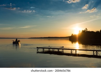 Cottage Life - Father and son fishing on a boat at sunrise sunset at the peaceful cottage in Kawartha Lakes Ontario Canada on Balsam Lake - Powered by Shutterstock