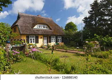 Cottage With Thatched Roof And A Pretty Garden