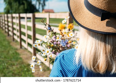 Cottagecore Farmcore Countrycore aesthetics, fresh air, countryside, slow life, pastoral life, outdoor picnics, wearing grandma clothes. Young girl in straw hat with flowers walks on country farm.